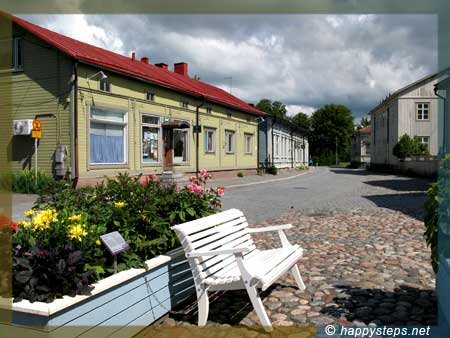 a white bench in front of the Rauma Museum photo of a white bench in front of the Rauma Museum