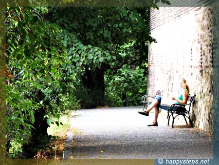 photo of a lady leisurely reading by the wall, Vysehrad Castle, Prague